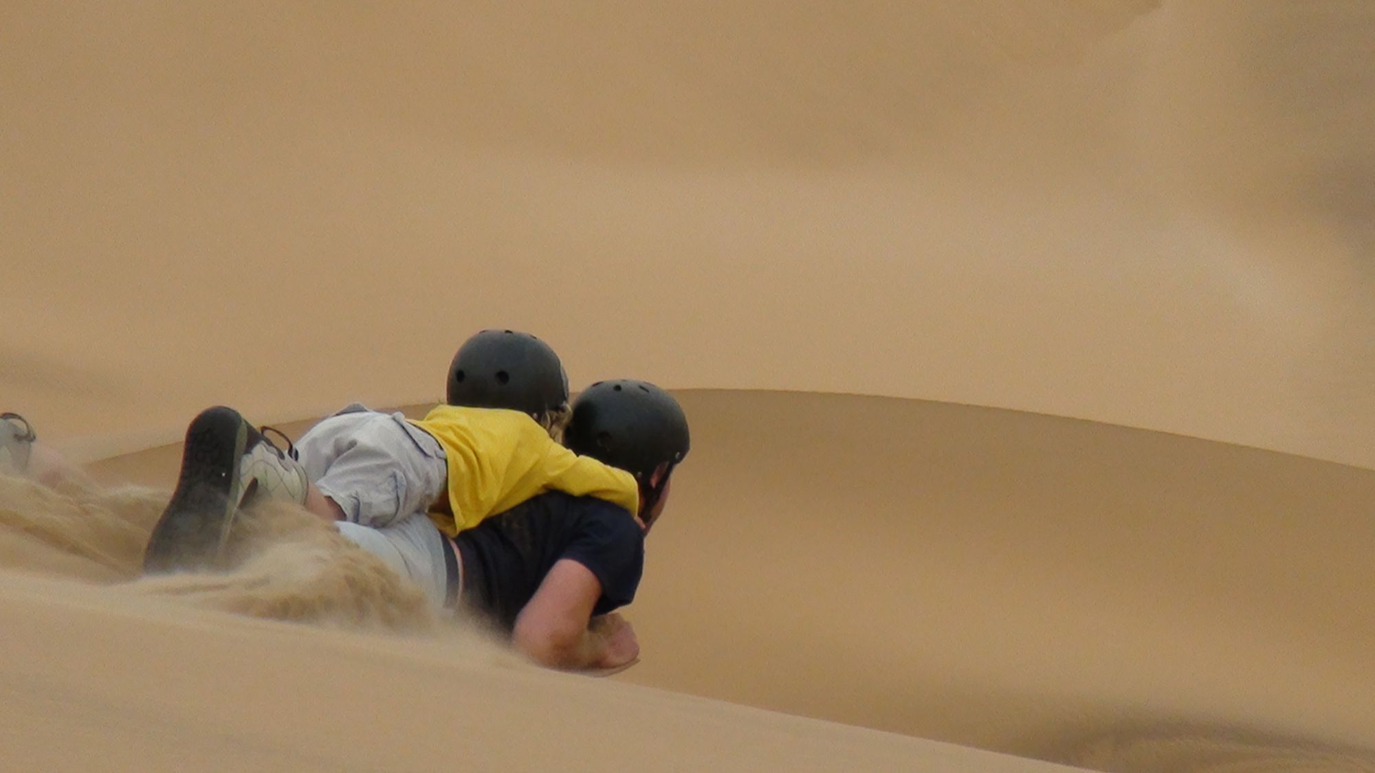 Sandboarding down a dune